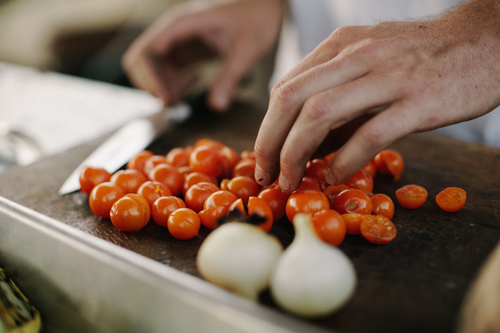 Person chopping cherry tomatoes