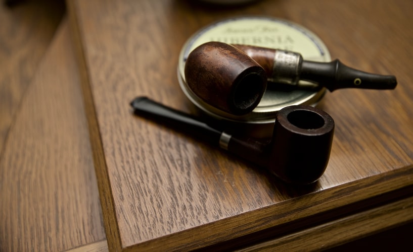 Two old authentic wooden smoking pipes with a tobacco case