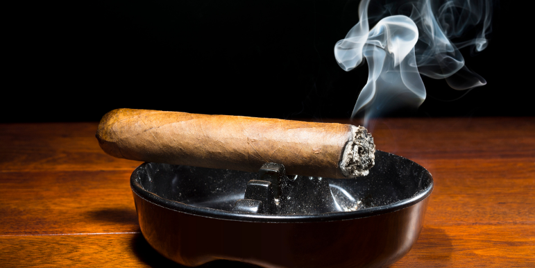 A cigar burning out in an ashtray