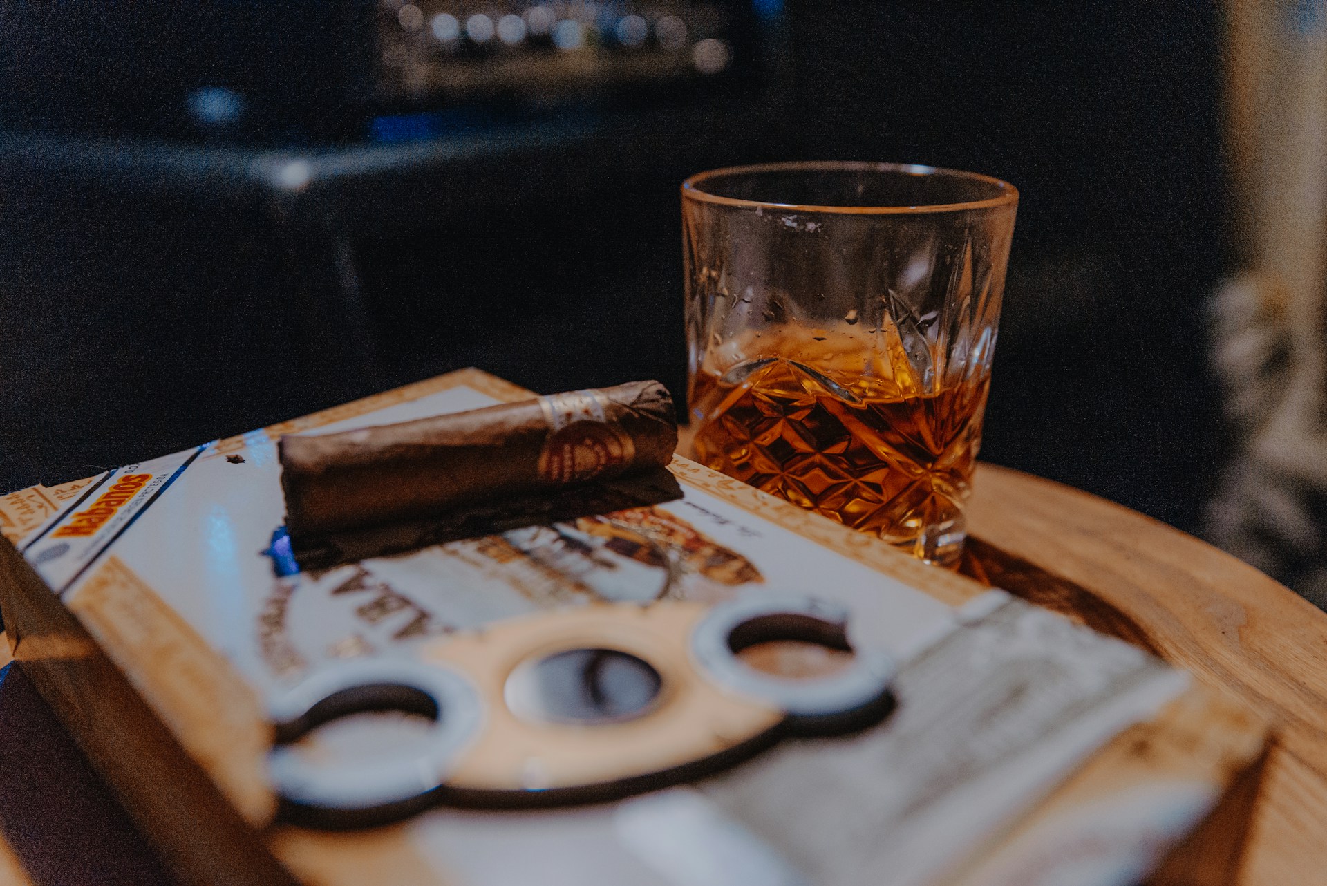 A half-smoked cigar with a cigar cutter and drink