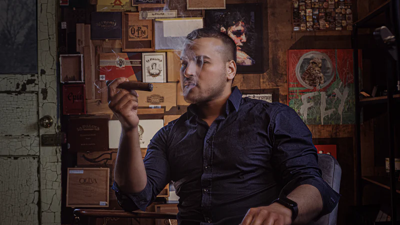 A man sat smoking a cigar