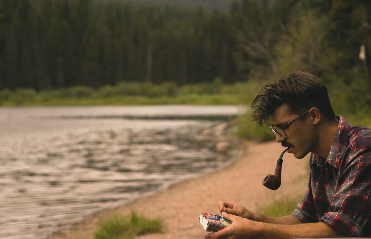 Man smoking pipe tobacco through a pipe