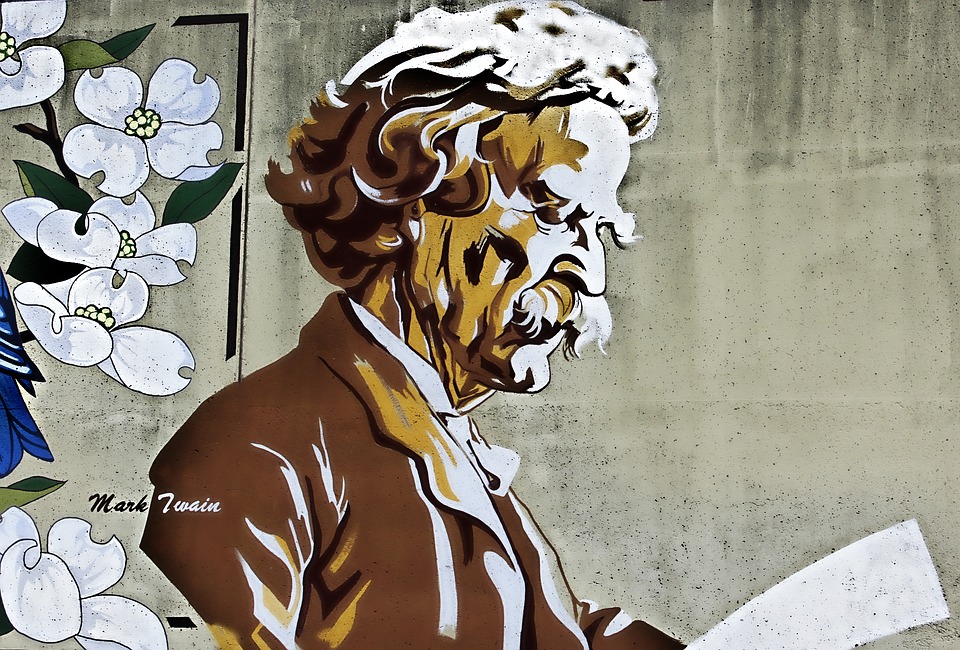 A painting mural of Mark Twain reading surrounded by flowers