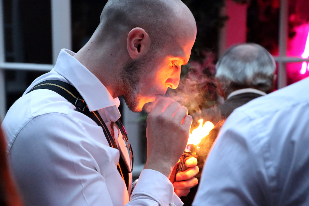 man lighting a cigar