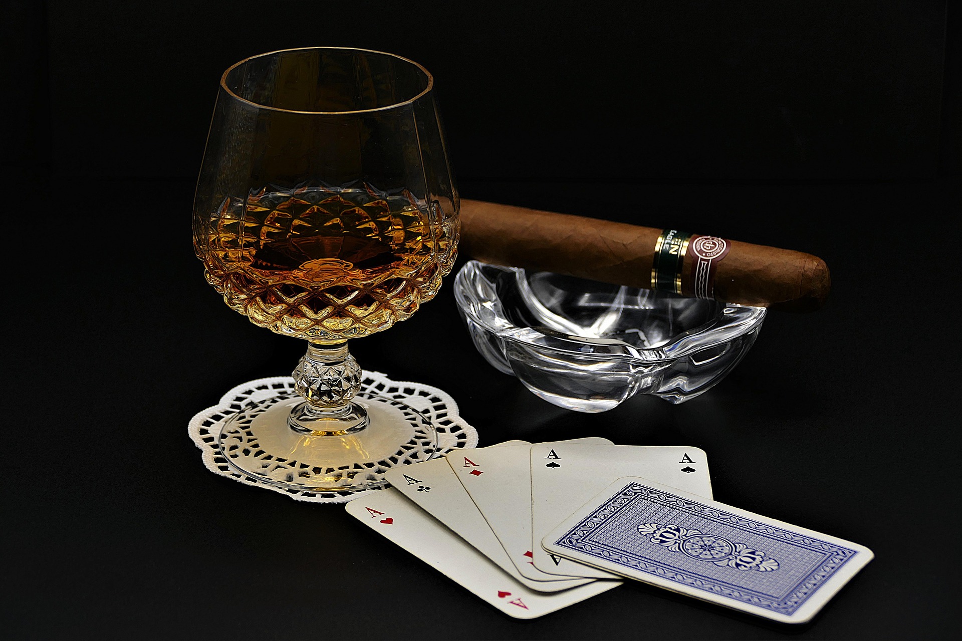 Whisky, poker cards and cigars on a table