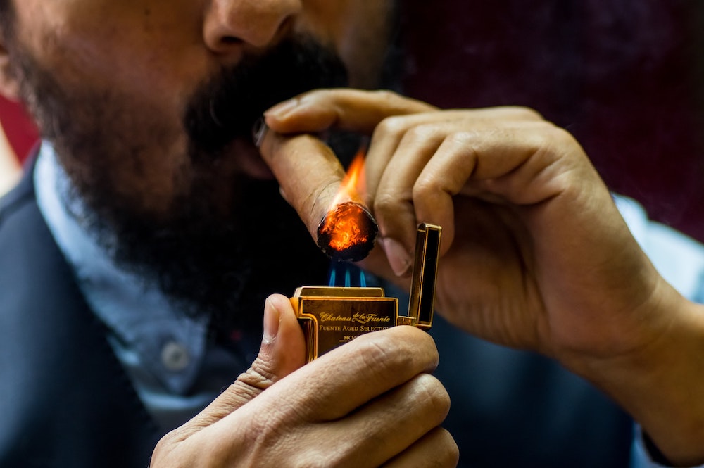 man lighting cigar