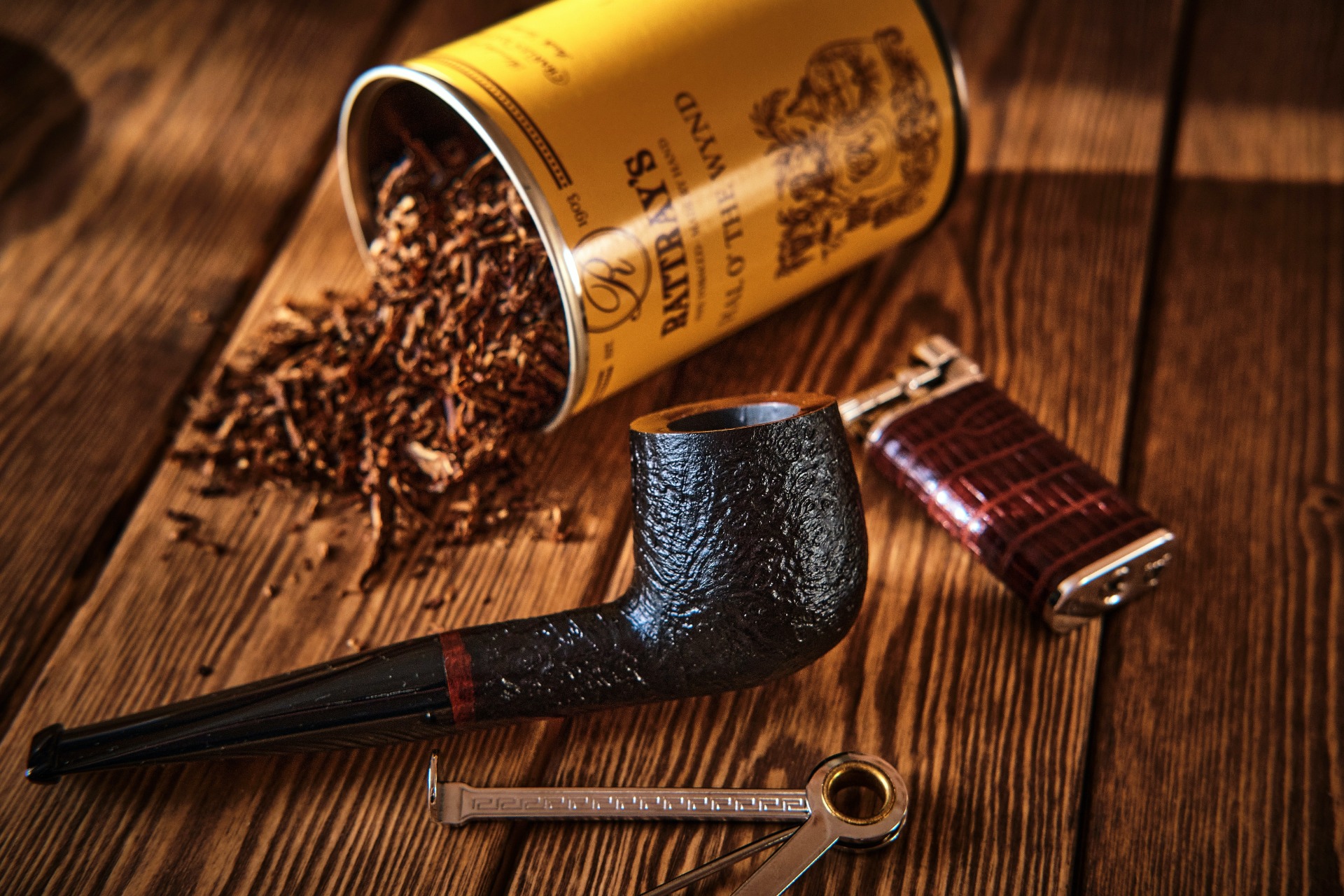 A pipe, a lighter and a spilt tin of tobacco