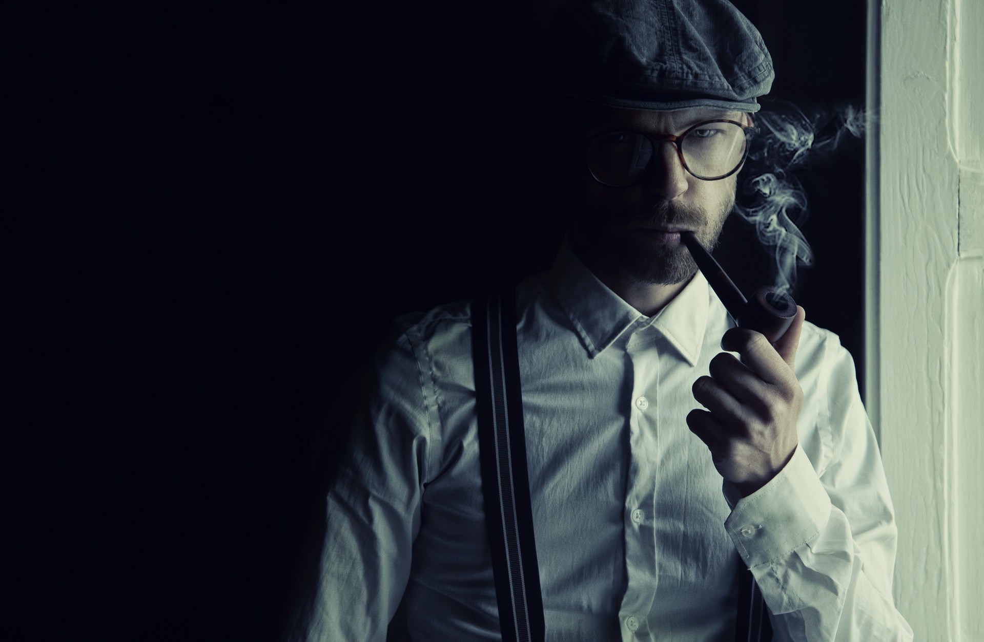 a man in a flat cap smoking a pipe